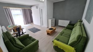 uma sala de estar com um sofá verde e uma mesa em Pomiculturii Residence 8 em Timisoara