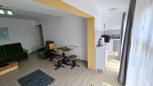 uma sala de estar com uma mesa e uma cozinha em Pomiculturii Residence 8 em Timisoara