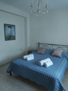 1 dormitorio con 1 cama azul y 2 almohadas en Villa Marilena, en Nafpaktos