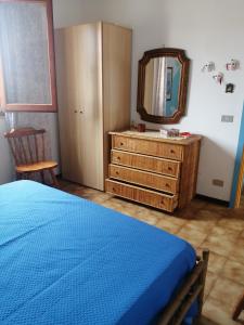 a bedroom with a bed and a dresser and a mirror at La casa di Mo' in Torre Dei Corsari