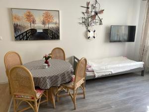 ein Esszimmer mit einem Tisch, Stühlen und einem Bett in der Unterkunft Cichy Zaułek 5 i 6 in Brodnica