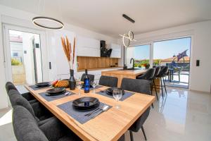 cocina y comedor con mesa de madera y sillas en Villa Mina with a private pool in Pula, en Pula