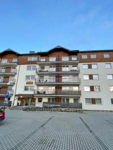 a large building with a parking lot in front of it at Apartament Błękitne Spa in Ustrzyki Dolne