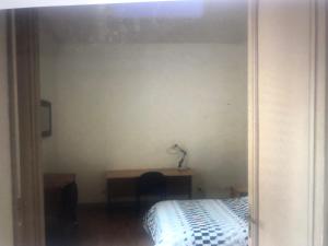 1 dormitorio con cama, escritorio y espejo en Metz-sud - Appartement 120 m2 dans maison du XVIII - Jouy aux Arches entre Nancy et Luxembourg - Proximité toutes commodités, en Jouy-aux-Arches