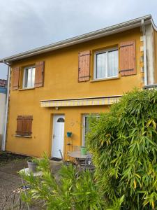 居讓梅斯特拉的住宿－L'ambre salée，黄色的房子前面设有桌椅