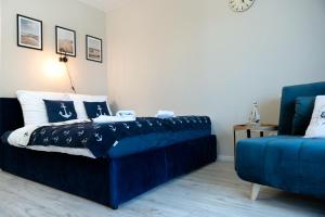 a bedroom with a blue bed and a blue couch at Blue Baltic & SPA in Dziwnów +48 photos