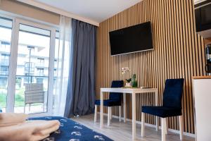 a room with a table and a tv on a wall at Blue Baltic & SPA in Dziwnów