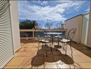 a patio with a table and chairs on a balcony at Casa Praga in Roses