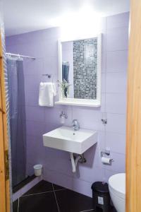 a purple bathroom with a sink and a toilet at Το Μεγάλο Αμπέλι in Megalochori