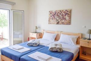 una camera da letto con un letto e asciugamani di Το Μεγάλο Αμπέλι a Megalochori
