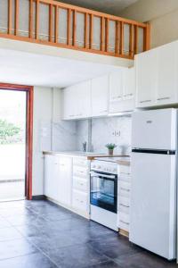 a kitchen with white cabinets and a white refrigerator at Το Μεγάλο Αμπέλι in Megalochori