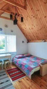 sypialnia z łóżkiem i drewnianym sufitem w obiekcie Вулик будиночок з двома окремими номерами w Kamieńcu Podolskim