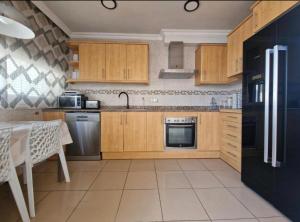 羅薩斯的住宿－Casa Praga，厨房配有木制橱柜和黑色冰箱。
