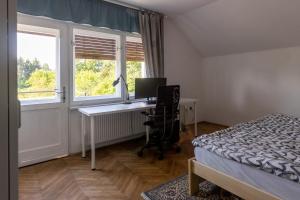 a bedroom with a desk with a computer and a window at Apartment Bogomila in Ljubljana