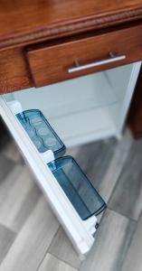 un tiroir avec deux téléphones portables à l'intérieur dans l'établissement Вулик будиночок з двома окремими номерами, à Kamianets-Podilsky