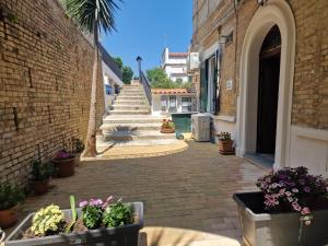 un callejón de ladrillo con escaleras y flores en ollas en B&b SIRENA DI FRANCAVILLA AL MARE, en Francavilla al Mare