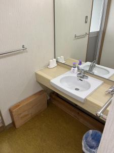 a bathroom with a sink and a mirror at Enmanin Sanmitsuden - Vacation STAY 39449v in Otsu