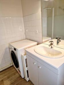 a bathroom with a washing machine and a sink at Studio centre-ville au calme in Espalion