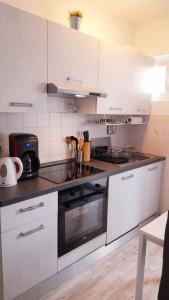 een keuken met witte kasten en een fornuis met oven bij Apartman Vortex in Malinska