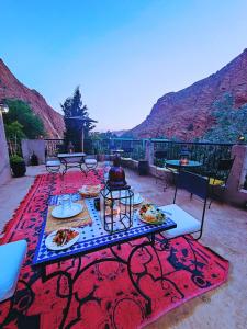 a table with plates of food on top of a rug at Auberge La Fibule Du Dades in Aït Idaïr