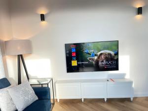 a living room with a flat screen tv on a wall at Zaspa VVita Sea View Apartment in Gdańsk