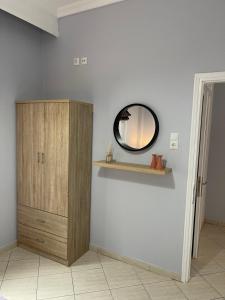 um quarto com um espelho e um armário de madeira em Seabayhome em Nea Peramos