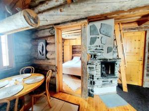 a cabin with a bed and a table and a fireplace at Ruka Monokolo, log apartment in Eastern Ruka in Kuusamo +13 photos