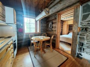 a kitchen with a table and chairs in a cabin at Ruka Monokolo, log apartment in Eastern Ruka in Kuusamo