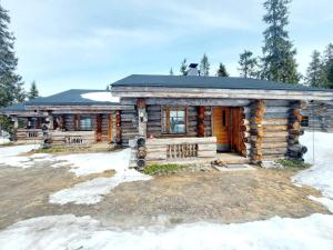 a log cabin in the winter with snow on the ground at Ruka Monokolo, log apartment in Eastern Ruka in Kuusamo