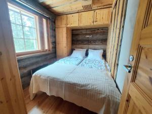 uma cama num pequeno quarto com uma janela em Ruka Monokolo, log apartment in Eastern Ruka em Kuusamo