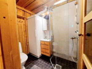 uma casa de banho com um chuveiro, um WC e um lavatório. em Ruka Monokolo, log apartment in Eastern Ruka em Kuusamo