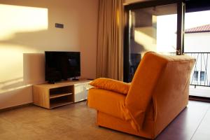 a living room with a chair and a television at LeNo in Umag