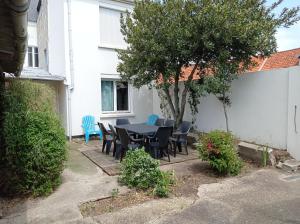 einen Tisch und Stühle im Hinterhof eines Hauses in der Unterkunft Appartement duplex avec cour 10 pers in Berck-sur-Mer