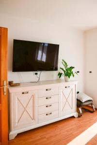 una cómoda blanca con una TV encima en Apartment Laetitia, en Kaštelir