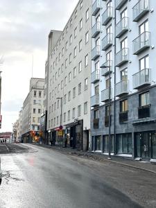 een lege straat voor een gebouw bij Uusi upea kaksio Tampereen ytimessä, pysäköinti, iso lasitettu parveke in Tampere