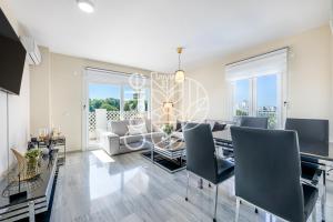 jadalnia i salon ze stołem i krzesłami w obiekcie APARTAMENTO VACACIONAL A 10 MIN PUERTO DE BENALMADENA Y LA CARIHUELA PISCINA PLAYA PARKING GRATIS w mieście Torremolinos