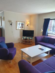 a living room with purple couches and a coffee table at Apartment Kongsgård in Kristiansand