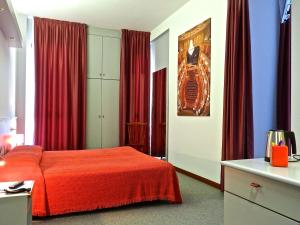 a bedroom with a red bed and red curtains at Hotel Italia in Stradella +50 photos