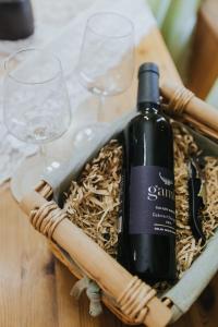een fles wijn in een mand op een tafel met glazen bij צימר בלוטים באמנון in Amnon