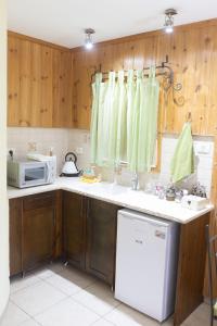 een keuken met houten kasten en een witte koelkast bij צימר בלוטים באמנון in Amnon