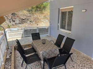 patio con mesa y sillas en el balcón en Seabayhome en Néa Péramos