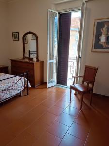 a bedroom with a bed and a chair and a mirror at Casa vacanze Scilla in Scilla