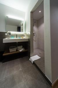 a bathroom with a shower and a sink and a mirror at Hotel Terrace in Bettendorf