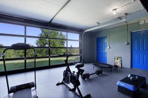 una habitación con un gimnasio con bicicletas estáticas y ventanas en Tranquil Secluded Retreat en Columbia