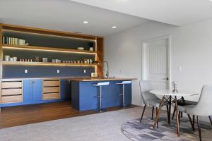 cocina con armarios azules, mesa y sillas en Tranquil Secluded Retreat en Columbia