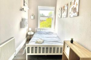 a small bedroom with a bed and a window at Modern 2 bed flat in Moseley in Birmingham