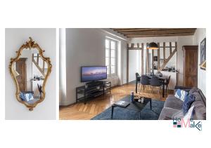 a living room with a couch and a mirror at L'essence du cachet in Saint-Germain-en-Laye