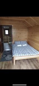 a bed in a room with a wooden wall at Green House Latin Grad in Vrmdža