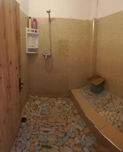 a bathroom with a shower with rocks on the floor at Auberge Village Paradise Valley in Tagherat Anekrim