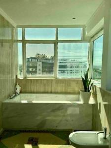 ein Badezimmer mit Badewanne und Fenster in der Unterkunft Exquisite Top Floor Apartment in the Bay of Tanger in Tangier